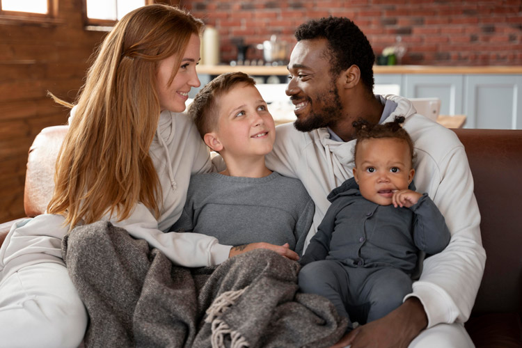 a family sitting on the couch with two kids