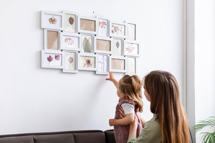 Child reaching for photos on wall