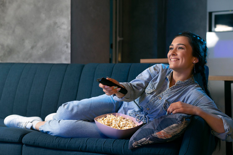 Girl sitting on couch with popcorn