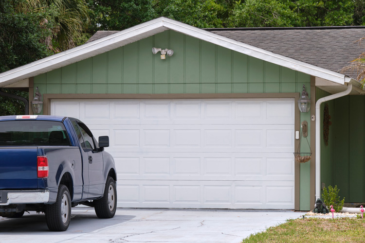 Pickup truck parked in driveway in front of new garage door.