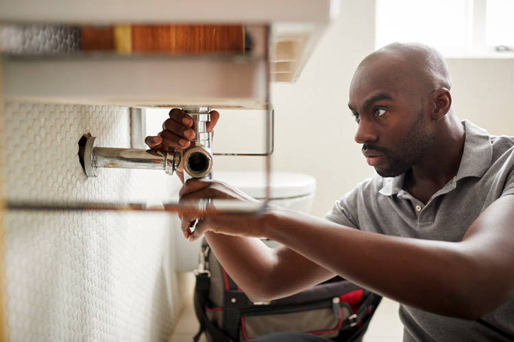 Plumber fixing bathroom sink.