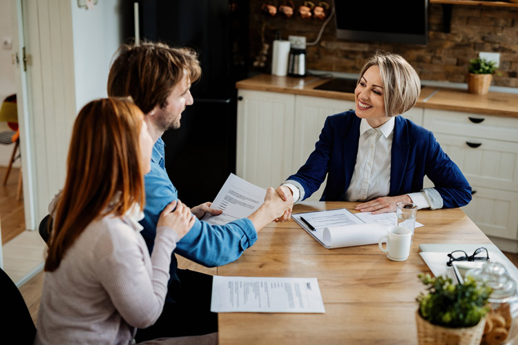 Two people making a real estate transaction with a real estate agent